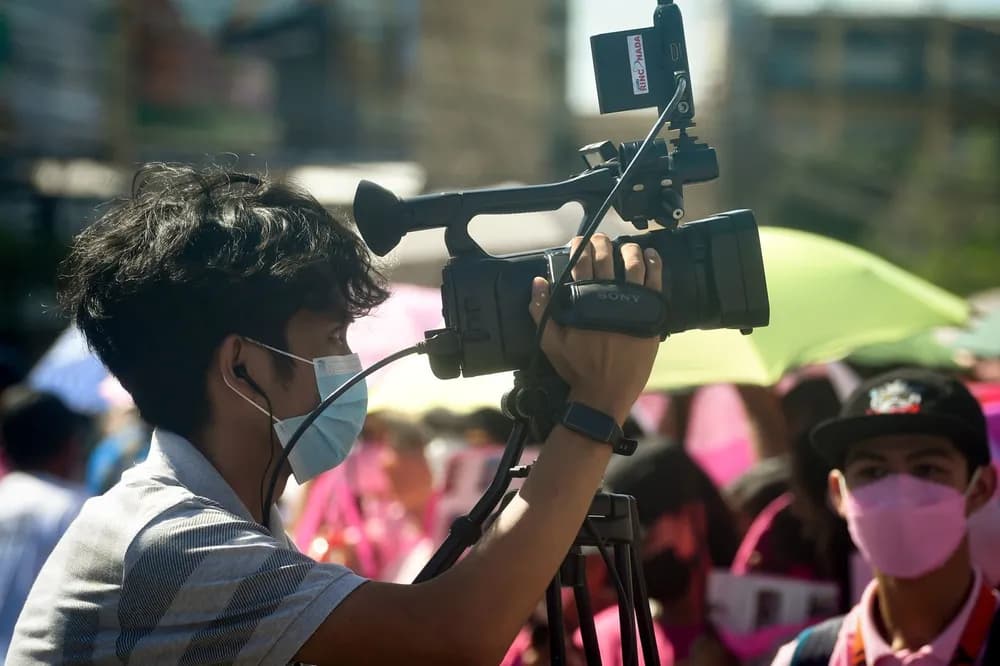 Camera operator filming a live event with a professional camcorder